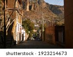 Panoramic view of a typical street with adobe buildings and stone pavement in Tepoztlan, Mexico, with the Tepozteco Mountain on the background. Magical town.