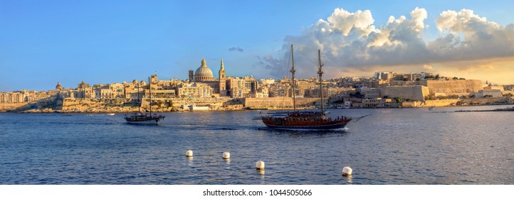 Panoramic view of Valletta waterfront with Carmelite Church dome and St. Pauls Anglican Cathedral at sunset sunlight. Malta