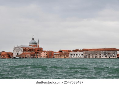 Panoramic View of Venetian Architecture by the Lagoon.
Scenic view of Venetian buildings and a historic church dome along the waterfront on a cloudy day. - Powered by Shutterstock