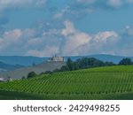 Panoramic view of vineyard and castle Taggenbrunn on soft hill in Sankt Georgen am Längsee, Sankt Veit an der Glan, Carinthia, Austria. Tranquil serene atmosphere in summer. Wine growing area