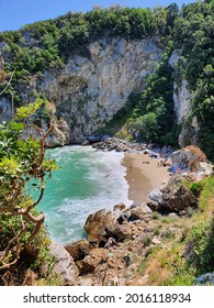 Panoramic view of a well hidden beach. Crowd of people relaxing in the sand. 