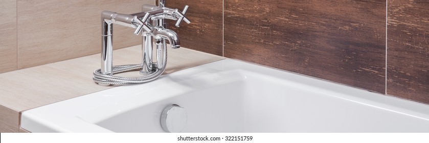 Panoramic view of white bathtub with silver old style tap