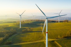Панорамный вид на ветряную электростанцию или ветропарк с высокими ветровыми турбинами для выработки электроэнергии с копировальным пространством. Концепция зеленой энергии.