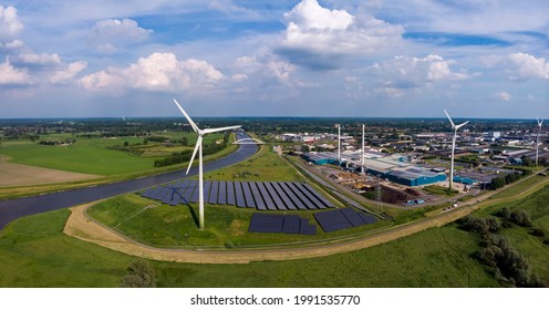 Panoramic view of wind turbines, water treatment and bio energy facility and solar panels in The Netherlands part of sustainable industry in Dutch river landscape. Aerial circular economy concept.