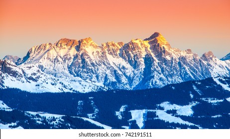 Panoramic View Of Winter Mountains. Alpine Peaks Covered By Snow And Illuminated By Rising Sun.