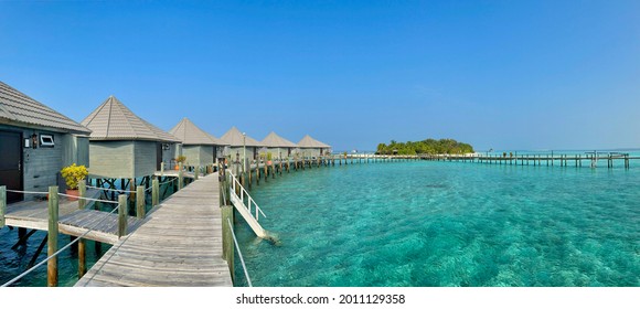 Panoramic View of Wooden Pier with Water Villa, Turquoise Ocean nad Island in Maldives. Maldivian Panorama of Overwater Bungalow, Laccadive Sea and Luxury Resort. - Powered by Shutterstock