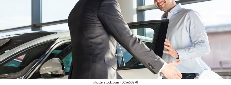 Panoramic View Of Young Elegant Man Getting Into The Car 