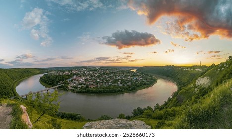 Panoramic view of Zalishchyky town nestled in a horseshoe bend of the Dniester River at sunset. Dramatic sky with colorful clouds over the lush landscape and meandering river - Powered by Shutterstock