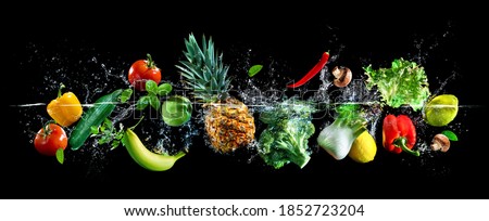 Panoramic wide black background with assortment of fresh vegetables, fruits and water splashes. High resolution collage for skinali