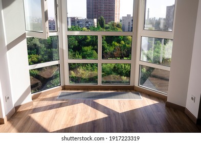 Panoramic window. Sharp shadows from the panoramic window frame on the wooden floor. Underfloor heater grill.