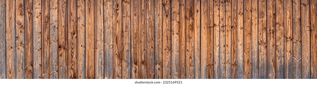 Panoramic wooden wall of a barn made of brown vertical, already weathered boards with intensive grain  - Powered by Shutterstock