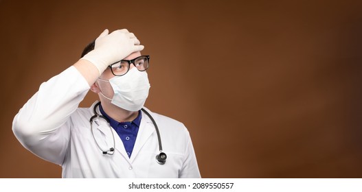 Panoramic Young Caucasian Doctor In A Medical Uniform Makes A Facepalm Gesture. Medical Errors And Stupidity