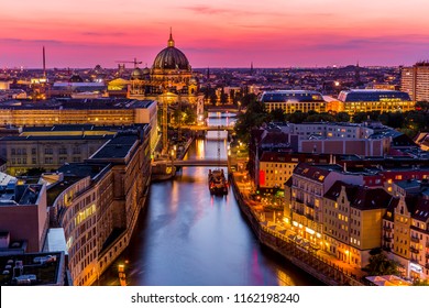 Panoromic  aerial view of Berlin skyline with famous TV tower and Spree river in beautiful post sunset twilight during blue hour at dusk with dramatic  colorful clouds , central Berlin Mitte, Germany