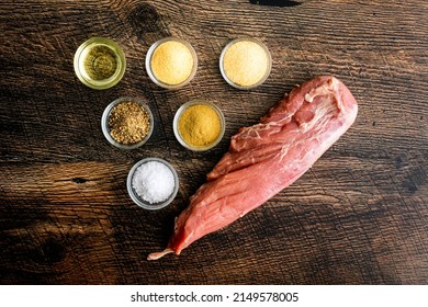 Pan-Roasted Herbed Pork Tenderloin Ingredients: Overhead View Of Raw Pork Tenderloin With Dried Spices And Olive Oil