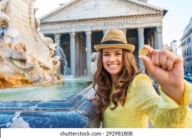 At The Pantheon Fountain And Pantheon In Summer, A Smiling Brunette Tourist Holds A Coin Up As She Prepares To Throw It Into The Pantheon Fountain To Make A Wish.