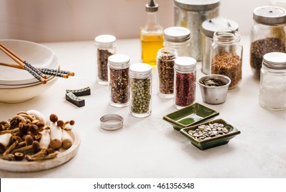 Pantry Full Of Different Spices And Condiments In Glass Jars.
