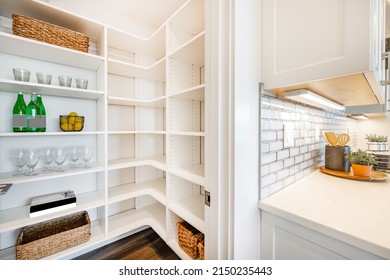 pantry and mudroom with white walls shelving hardwood floor - Shutterstock ID 2150235443
