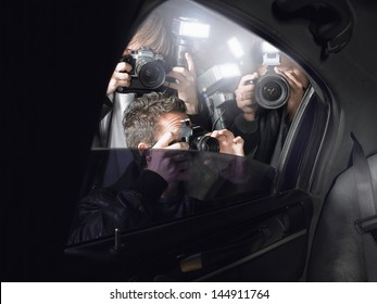 Paparazzi taking pictures through car window - Shutterstock ID 144911764