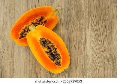 Papaya fruit on light wooden background. Slices of sweet papaya on wooden background, Halved papayas