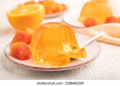 Papaya And Orange Jelly On Gray Concrete Background And Orange Linen Textile. Side View, Flat Lay, Close Up, Selective Focus.