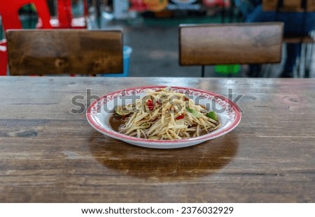 Papaya salad,street food in Thailand.Somtam.Papaya salad in a plate placed on a table in a restaurant.