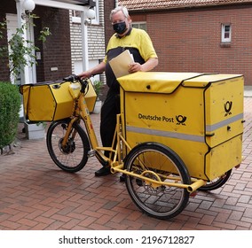 Papenburg, Germany - June 17 2022 A Friendly Postal Worker From The German Post With A Protective Mask Is Kind Enough To Pose. The Mail Is Delivered Here With A Special Bicycle.