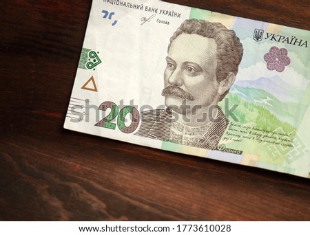 Paper 20 or twenty hryvnia notes with famous Ukrainian historical figure Ivan Franco on it. New Ukrainian money on wooden background. Cash money. Close up shot.