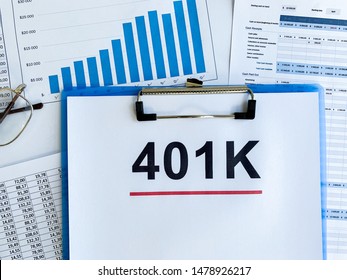 Paper With 401k Plan On Wood Table.