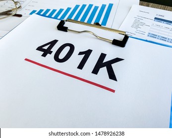Paper with 401k plan on wood table.