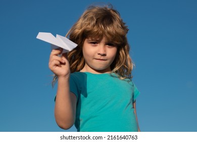 Paper Airplane In Children Hands, Child Throwing A Paper Airplane Into The Sky. Origami Paper Airplane.