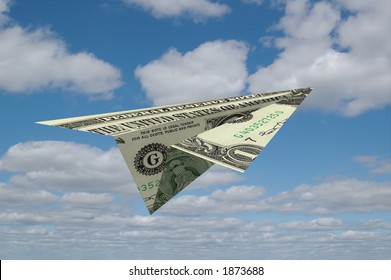 Paper Airplane Made Out Of Money With Clouds In The Background