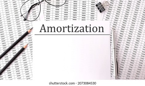 Paper with AMORTIZATION on table with chart and pencils