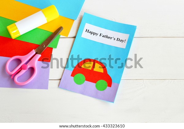 Paper art card with red car craft and text Happy\
father\'s day. Colored paper, scissors, glue stick. Materials used\
for creating handmade card. Children paper handcraft greeting card\
diy gifts for dad