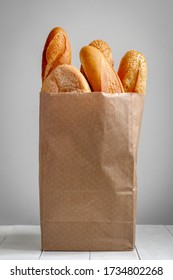 A Paper Bag With Bread On The Grey Background.