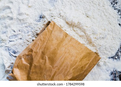 A Paper Bag Of Flour On The Table, Some White Wheat Flour Spilled Out Of The Bag