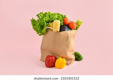 Paper bag with fresh vegetables on pink background. Grocery shopping concept - Powered by Shutterstock