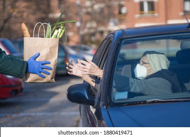 Paper Bag With Groceries Handed To Needy Elderly Person In Vehicle