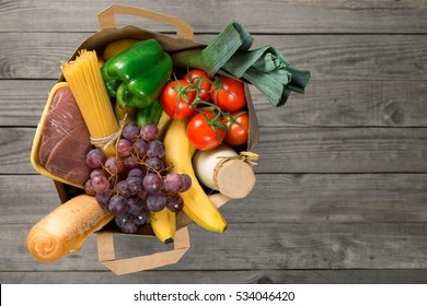 Paper Bag Of Groceries On Wooden Table With Copy Space, Top View