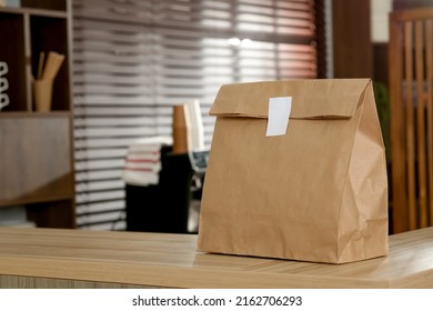 Paper Bag On Wooden Counter In Cafe, Space For Text