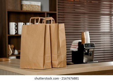 Paper Bag On Wooden Counter In Cafe, Space For Text