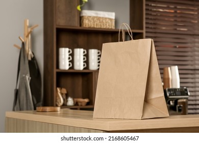 Paper Bag On Wooden Counter In Cafe, Space For Text