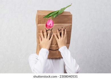 A paper bag and painted smiling face the child's head  The concept an anonymous gift 