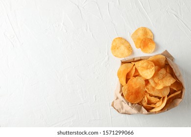 Paper bag of potato chips on white wooden background, space for text. Top view - Powered by Shutterstock