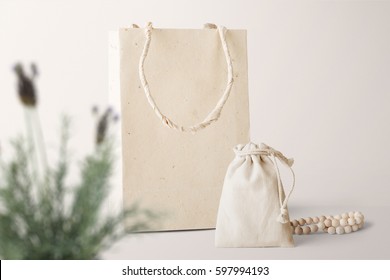 Paper Bag And Pouch Mockup, Front View, With Decor Elements, Plants And Blank Copy, Logo Space On Pastel Background.