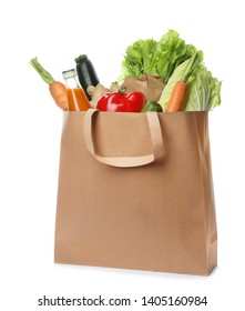 Paper bag with vegetables and bottle of juice on white background