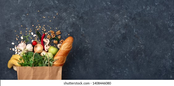 Paper bag vegetables and fruit on a dark background with copy space top view. Bag food concept - Powered by Shutterstock