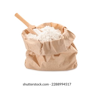 Paper bag with wheat flour and wooden scoop isolated on white background
