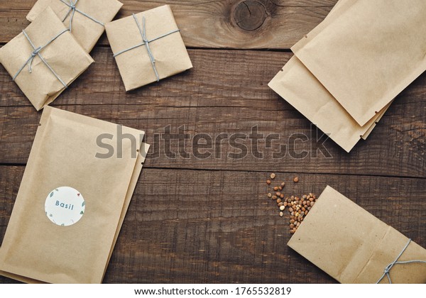 Paper bags with seeds for planting. Wooden table.\
View from above.