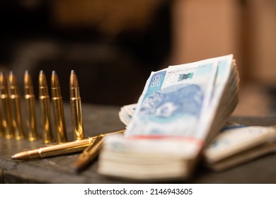 Paper Banknotes And Rifle Cartridges Lie On A Crate.