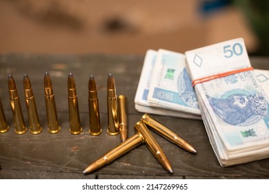 Paper Banknotes And Rifle Cartridges Lie On A Crate.